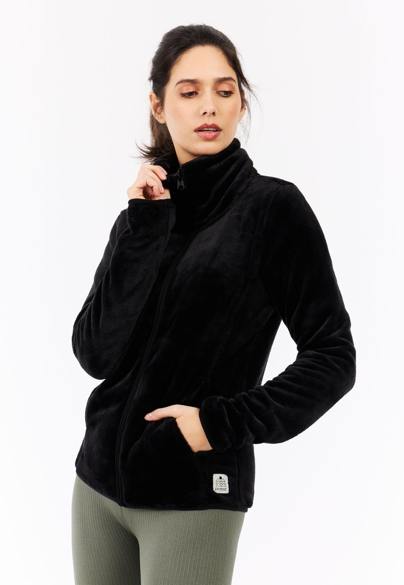 Schwarze Fleecejacke mit hohem Kragen, durchgehendem Reißverschluss und Seitentaschen. Glatte Textur mit einem Markenschild am Saum.