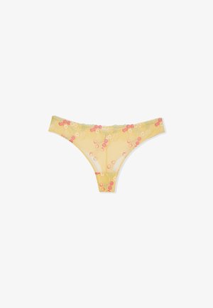 Gelber transparenter Spitzen-String mit rosa und weiß besticktem Kirschmuster auf weißem Hintergrund.