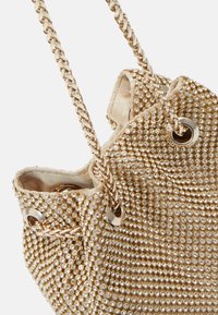 Guld håndtaske med en tekstureret overflade dækket af små, skinnende rhinsten, med en kæderem og metalliske øjennåle detaljer.