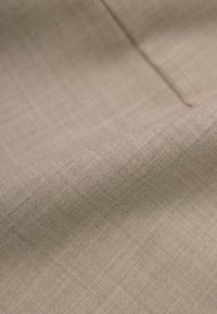 Beżowa tkanina teksturowana z drobnym wzorem w kratkę, charakteryzująca się gładką powierzchnią i miękkim opadaniem.