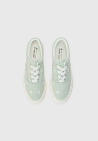 Green canvas sneakers featuring white eyelets and laces, adorned with small flower embroidery. Thick white rubber soles for support.