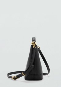 Black leather handbag with a triangular shape, gold hardware, and an adjustable strap, featuring smooth texture and minimalist design.