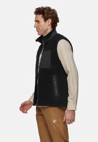 Zwarte fleece vest met een hoge kraag, een ritssluiting aan de voorkant en twee zijzakken, met een contrasterend stoffen paneel op de borst.