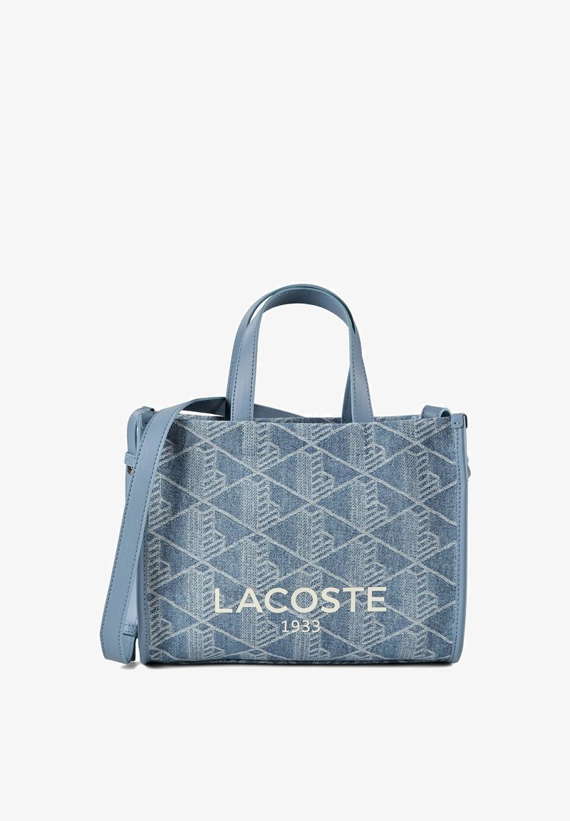 Borsa a mano in denim blu Lacoste con motivo geometrico, due manici, una tracolla e "LACOSTE 1933" stampato davanti.