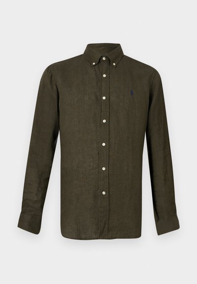 Σκούρο πράσινο πουκάμισο με μακριά μανίκια και κουμπιά, με κοντό γιακά που κλείνει με κουμπί και μικρό κεντητό λογότυπο στο αριστερό στήθος.