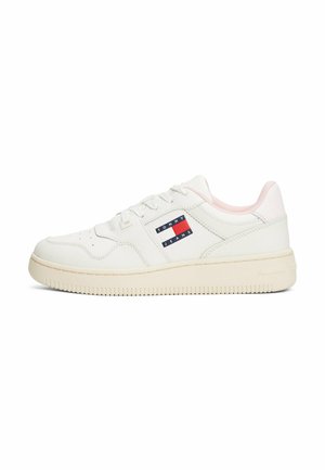 White leather sneaker with a low-top design, light pink accents, perforated toe, and a blue and red logo patch on the side. Textured rubber sole.