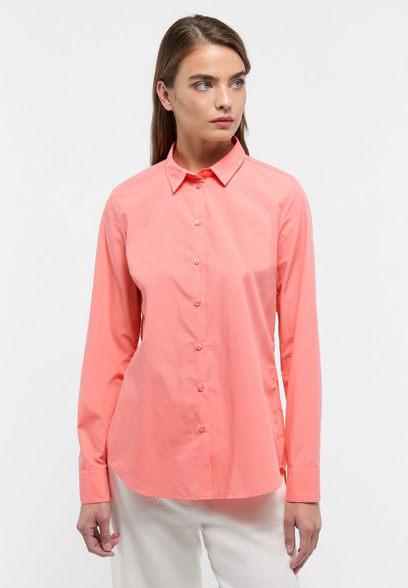 Coral button-up shirt made from lightweight fabric, featuring a pointed collar, long sleeves, and a curved hem. Smooth texture and simple design.