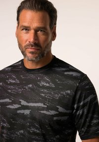 Zwarte sport T-shirt met abstracte donkergrijze golfpatronen, korte mouwen en een ronde hals, gemaakt van een ademende, vochtafvoerende stof.