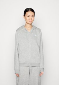 Siv hoody na zadrgo iz mehkega blaga z kapuco, rebrastimi manšetami in sprednjim logotipom. Umatched z ujemajočimi sivimi trenirkami.