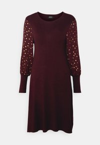 Robe bordeaux avec de longues manches bouffantes ornées de pois dorés. Fabriquée en tissu doux, elle possède un col rond et un ourlet légèrement arrondi.