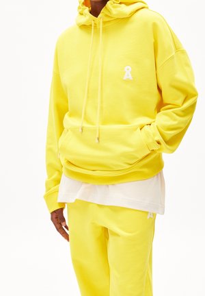 Sweat à capuche jaune et pantalon de jogging assorti, le sweat comporte une poche avant et des cordons de serrage ; les deux articles présentent un logo brodé.