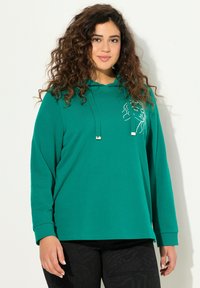 Felpa verde a maniche lunghe con vestibilità rilassata, dotata di cappuccio e cordini, e un design a disegno lineare minimalista sul davanti.