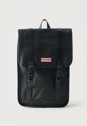 Melna taisnstūrveida mugursoma ar aizvēršanas atloku, divām priekšējām sprādzēm, augšējo rokturi un nelielu "HUNTER" logotipa plāksteri priekšpusē.