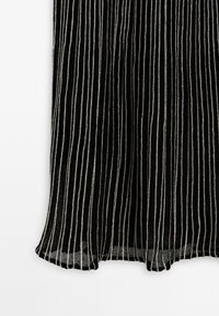 Gonna nera plissettata con strisce argento, che mette in mostra un tessuto testurizzato e un design fluido, adatta per abbigliamento formale o casual.
