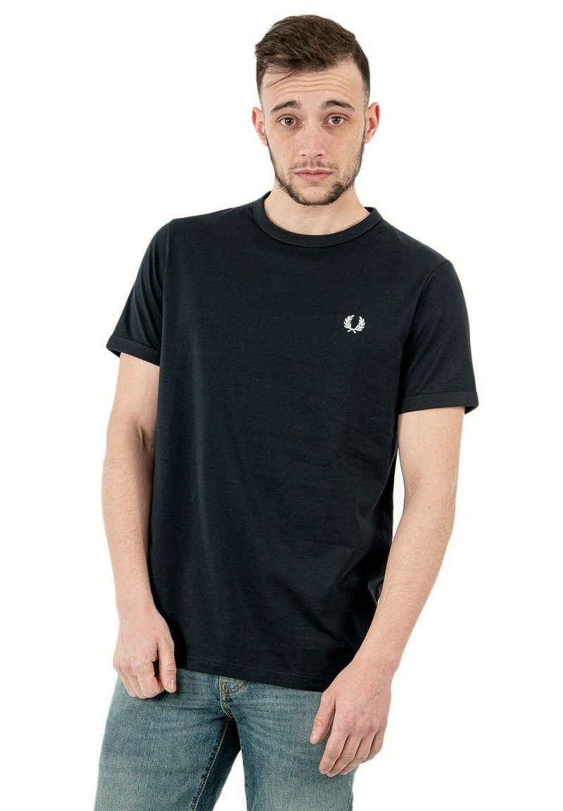 T-shirt nera in cotone, con collo rotondo e maniche corte. Include un piccolo emblema bianco sulla parte sinistra del petto.
