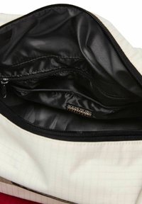 Vista interna di una borsa bianca che mostra la fodera in tessuto nero, una tasca con zip e un'etichetta del marchio Napapijri all'interno del compartimento principale.