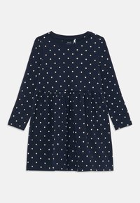 Abito blu navy a maniche lunghe con pois bianchi, realizzato in tessuto morbido, caratterizzato da una gonna arricciata e un collo rotondo.