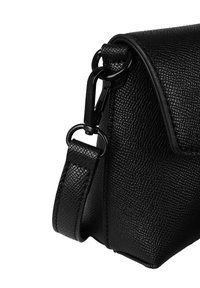 Černá kožená crossbody taška s texturovaným povrchem, vybavená klopou, kovovými detaily a nastavitelným ramenním popruhem.