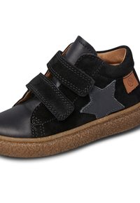 Baskets en daim noir avec un bout en cuir lisse, deux bandes Velcro, un accent étoile gris, et une semelle en caoutchouc brun texturée.