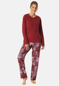 Langsleeve bordeaux top gecombineerd met bloempatronen pyjamabroeken in tinten van bordeaux en roze, met een ontspannen pasvorm en zachte stof.