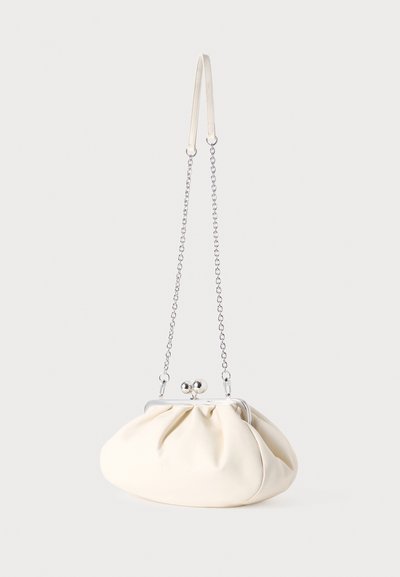 Sac à main en tissu couleur crème avec un design froncé, une bandoulière chaîne en argent et une fermeture à clip avec deux boutons arrondis sur le dessus.