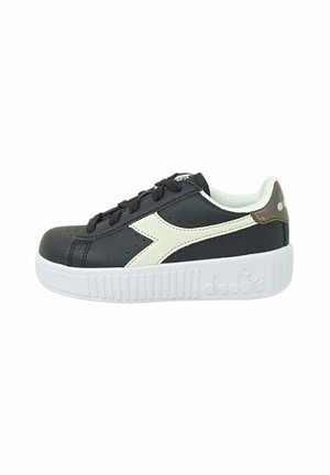Sneaker nera in pelle con suola in gomma bianca, caratterizzata da un design con striscia bianca diagonale e colletto imbottito. Comprende lacci e dettagli perforati.