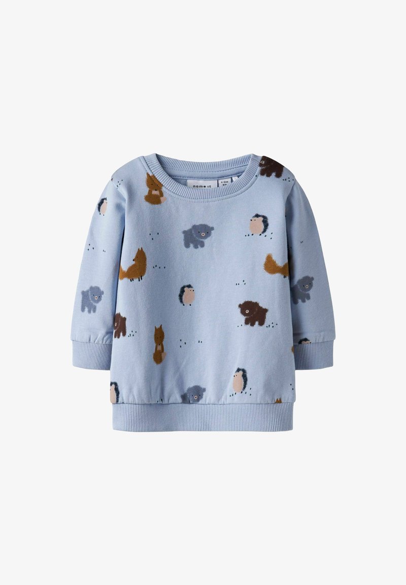 Gaiši zils sporta krekls ar zīmētiem dzīvnieku motīviem, tostarp lapsa, ezis un suņi, ar ribotām piedurknēm un apakšmalu.