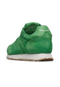 Sneaker verde in suede con una texture liscia, suola intermedia bianca, suola in gomma e un design minimalista. Presenta cuciture distintive e un branding sottile.