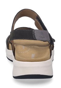 Czarne sandały z szerokim paskiem z tyłu, wyściełaną wkładką i białą podeszwą. Posiadają szare akcenty i gładką skórzaną teksturę.