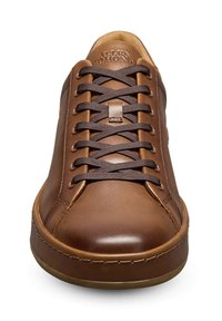 Sneaker en cuir marron avec une texture lisse, une pointe ronde et des lacets marron foncé. Comprend un logo subtil sur la languette et une semelle en caoutchouc.