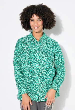 Grønne leopardprint knap-op skjorte med klassisk krave, lange ærmer og blødt stof. Inspirationen er kombineret med slidte grå jeans.