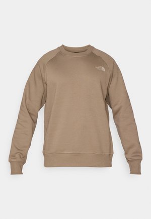 Sweatshirt din fleecă maro, cu mâneci lungi tip raglan, guler rotund și un mic logo pe piept. Textură netedă cu manșete și tiv cu dungi.