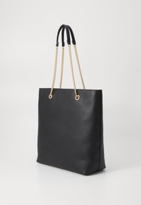 Black leather tote bag with a smooth texture, featuring gold chain straps and round hardware accents. Rectangular shape, minimalist design.