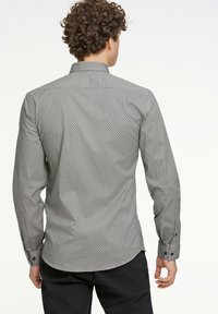 Camisa gris de mangas largas con un pequeño patrón geométrico, puños abotonados y un cuello clásico. Textura suave con un ajuste a medida.