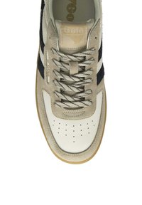 Beige och vit sneaker med mocka och läder material, med randiga svarta accenter, perforerad tå och texturerade snörningar.
