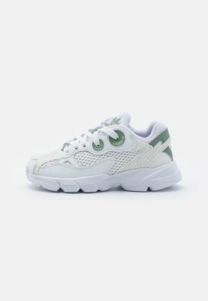 Sneaker bianca in rete con accenti verdi, lacci rotondi, pannelli strutturati e suola imbottita. Presenta il marchio sul lato e sulla linguetta.