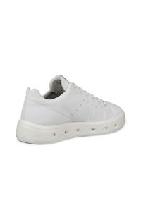Białe sneakersy z gładkiej skórzanej cholewki, okrągłym noskiem i ażurowymi detalami. Posiadają grubą gumową podeszwę z okrągłymi wycięciami oraz zapięcie na sznurówki.