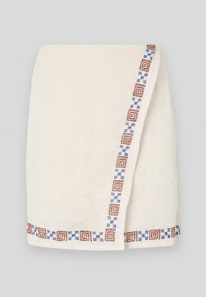 Cream-colored wrap skirt with textured fabric, featuring a patterned border in brown and blue geometric shapes along one side.