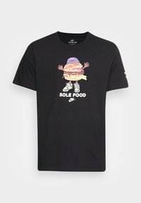 Schwarzes Baumwoll-T-Shirt mit einem lebendigen Motiv eines Burgers mit Armen, der einen lila Hut und Turnschuhe trägt. Der Text lautet "SOLE FOOD."