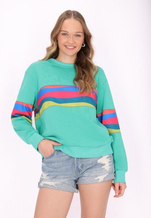 Turquoise sweatshirt met opvallende horizontale strepen in roze, blauw en geel. Lange mouwen en een relaxed fit. Draag met versleten denim shorts.