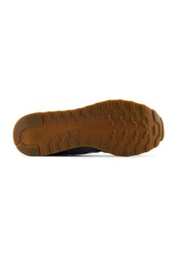 Sole di scarpa nera con suola in gomma testurizzata, caratterizzata da un motivo a onda e logo del marchio in rilievo. Design durevole e funzionale.