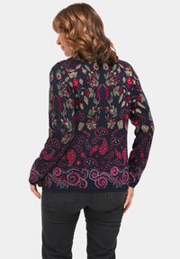 Gebreid sweater met een donkerblauw basis en meerkleurige bloemen- en paisleypatronen. Geribde manchetten en zoom, middellange uitvoering.