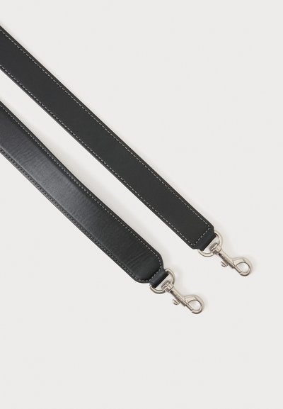 Deux sangles de sac en cuir noir avec fermoirs pivotants métalliques argentés sur fond blanc, montrant les détails des coutures le long des bords.