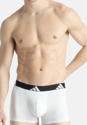 Weiße Baumwoll-Boxershorts mit einem schwarzen Bund, der drei weiße Streifen aufweist. Der Stoff ist glatt und eng anliegend, mit einem konturierten Beutel-Design.