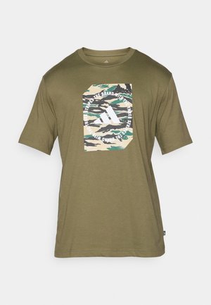 Oliwkowa koszulka z krótkim rękawem z prostokątną grafiką w wzór moro i białym logo oraz napisem Adidas na klatce piersiowej.