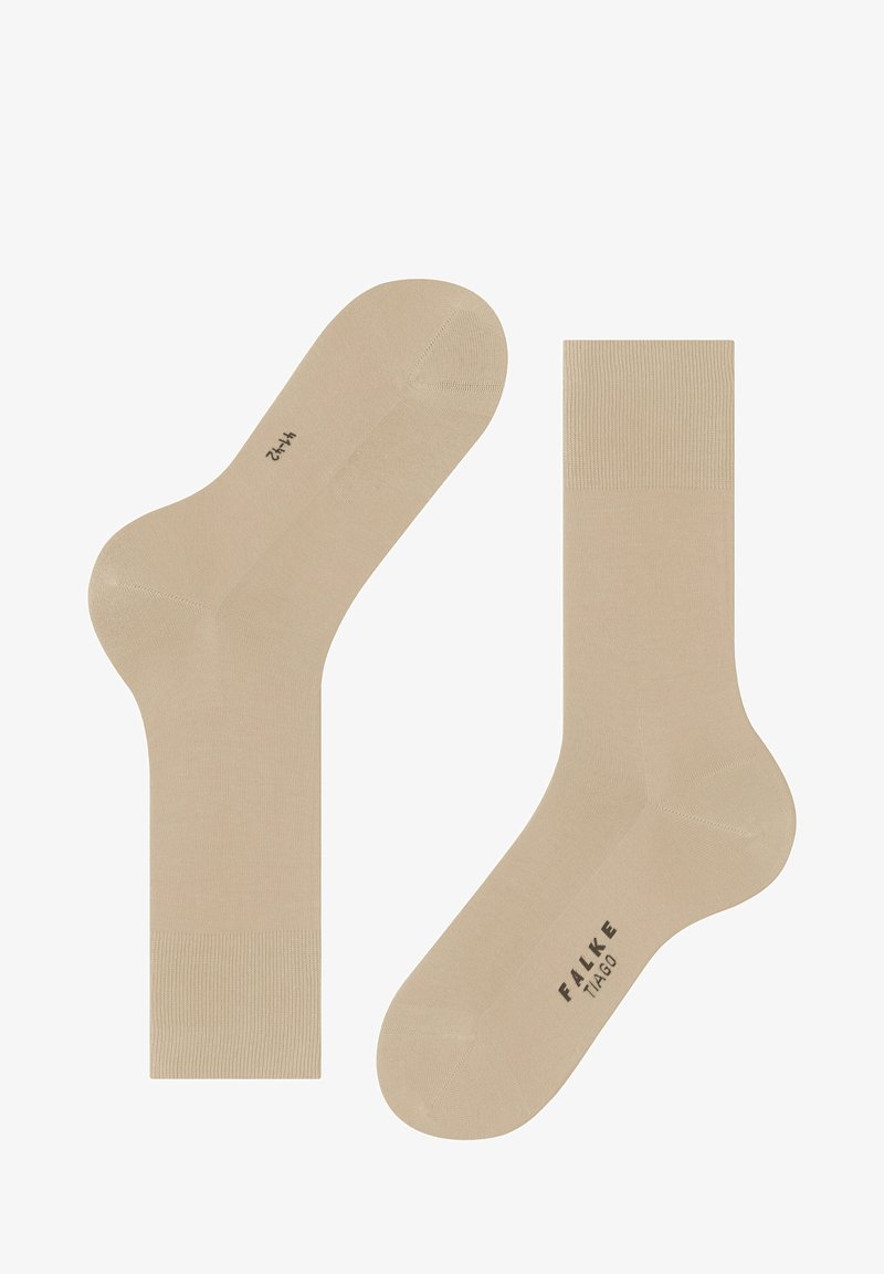 Calcetines de algodón beige con acentos acanalados en la parte superior, una textura suave y áreas reforzadas en el talón y la puntera; etiquetados como "FALKE TIAGO."