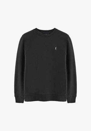 Sweatshirt noir en tissu doux, avec un col rond, des poignets côtelés et un petit logo blanc sur la poitrine. Texture lisse.
