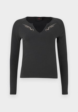 Maglietta nera a maniche lunghe con scollatura a V e texture a coste, con due design di ali argentate sulle spalle anteriori.