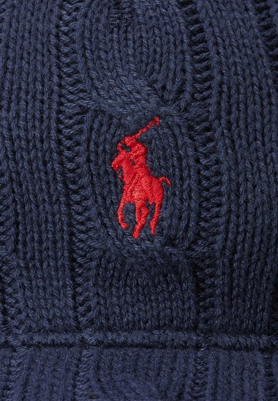 Marineblå strikkegenser med et strukturert kabelmønster og en fremtredende rød brodert polo hestelogo.