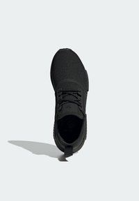 Svart sneaker med överdel i texturerad stickning, rund tå och snören. Har en dragflik vid hälen och ett mönstrat sulmönster för grepp.